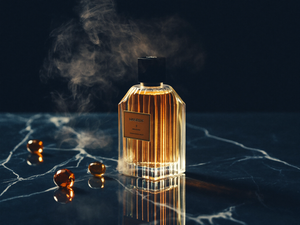 Luxury amber perfume bottle on navy marble — The Perfume Point